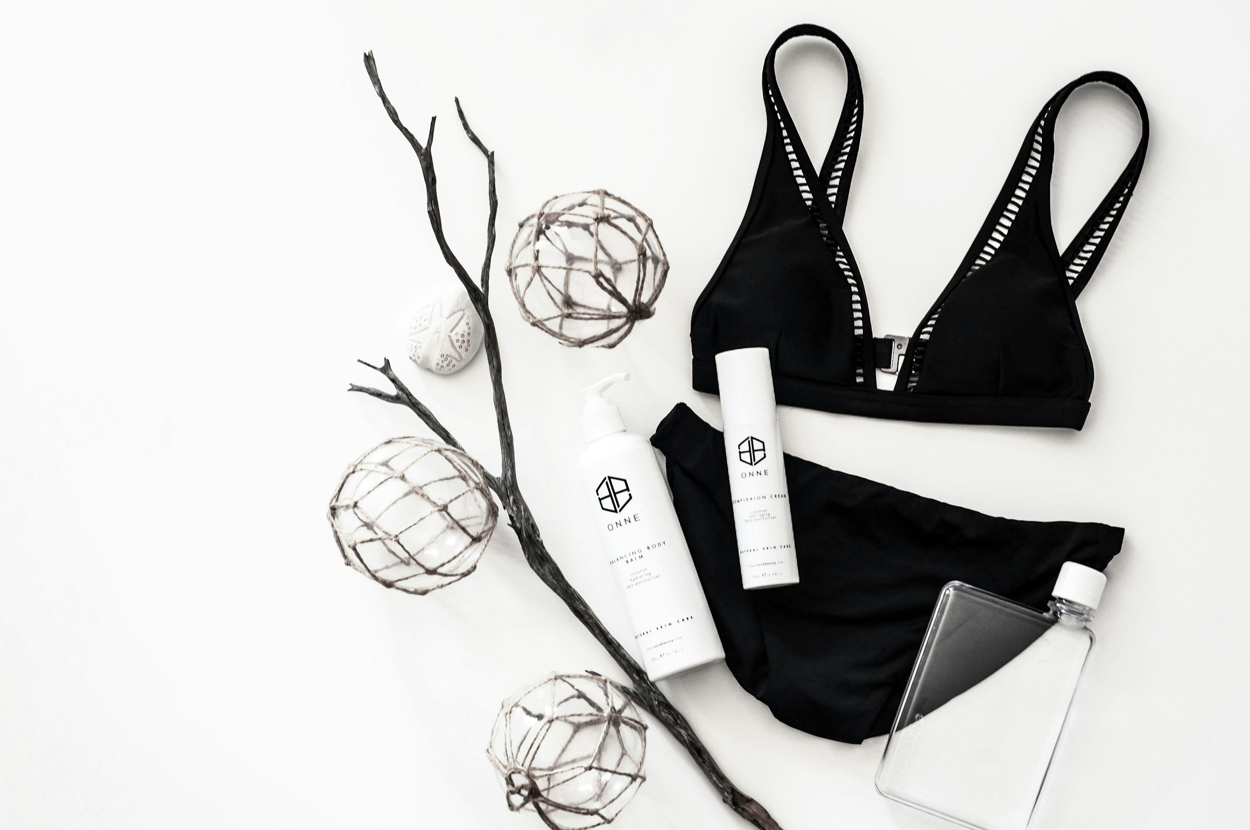 Flat lay of black lingerie set with skincare products and accessories for boudoir session preparation